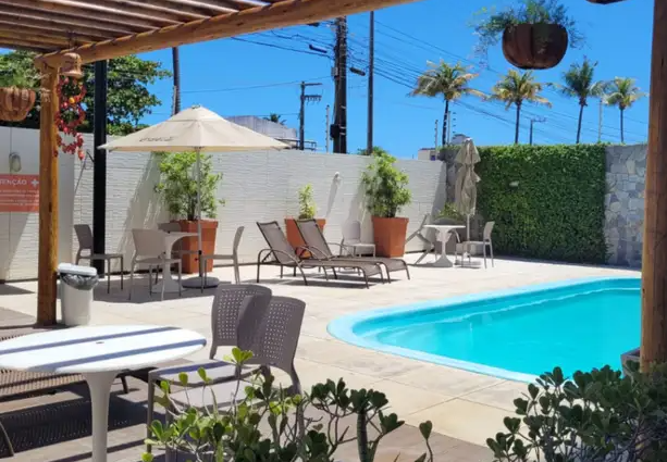 Piscina externa com espreguiçadeiras e palmeiras